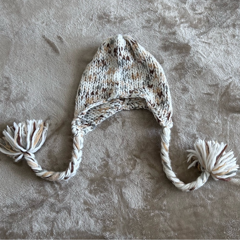Warm knit hat with hanging pompoms